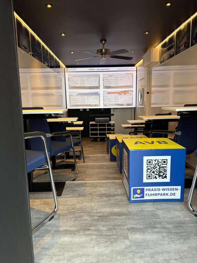 Blick in einen modernen Raum mit Tischen, Stühlen und Wandtafeln.